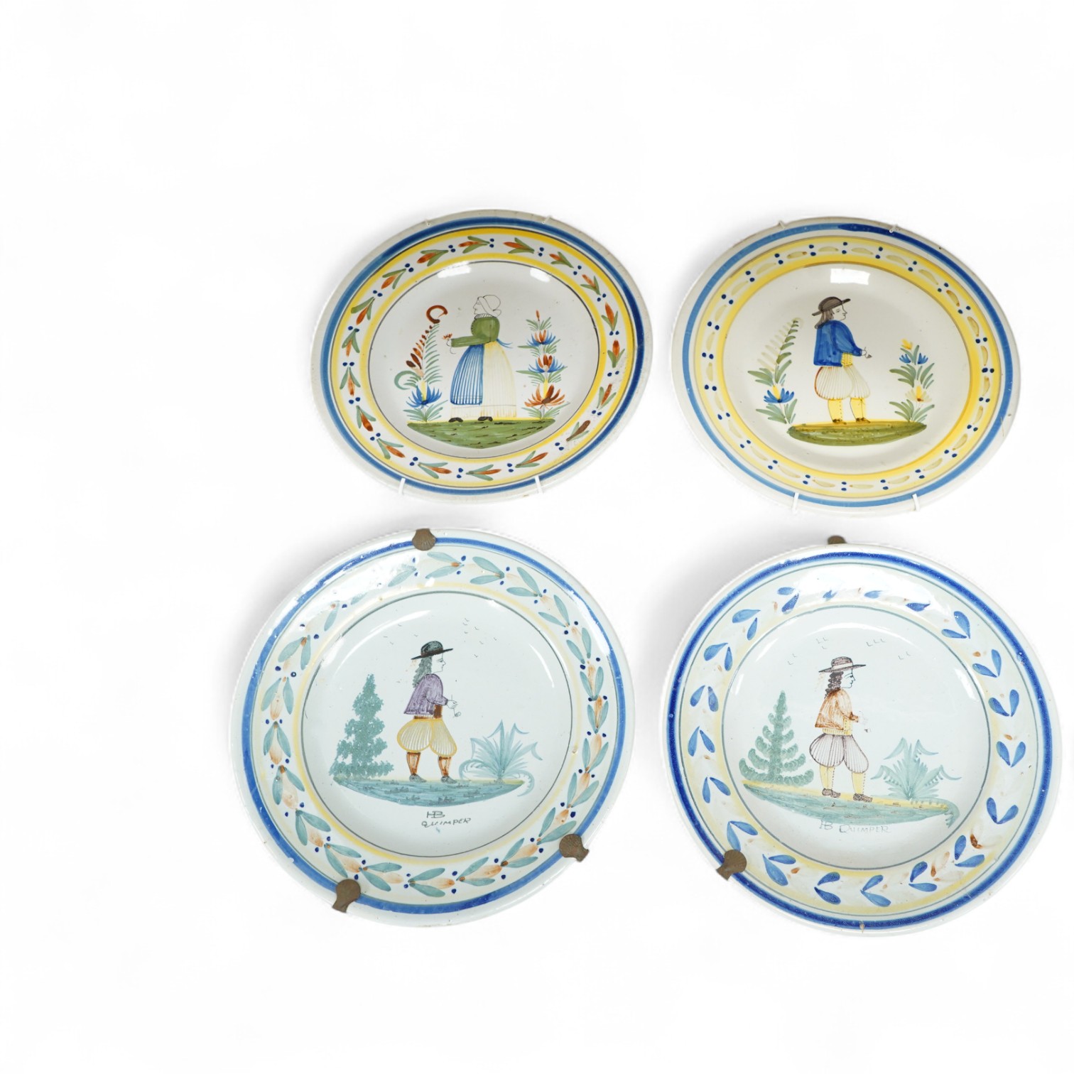 Four Quimper faience plates, each signed to the bases, 23cm in diameter